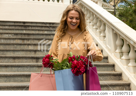 Young girl with paper bags, with flowers. 110907513