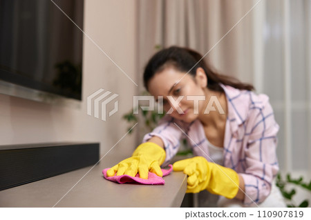 young woman in gloves cleaning and wiping table with microfiber cloth. chores at home. Housekeeping young woman in gloves cleaning and wiping table with microfiber cloth. chores at home. Housekeeping 110907819