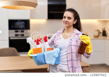 Woman in rubber protective yellow gloves holding cleaning tools. house chores. 110907822
