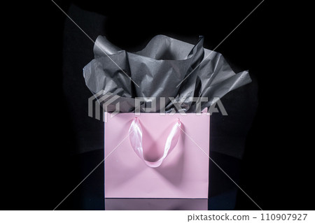Craft paper gift bag with tissue paper isolated on a black background 110907927