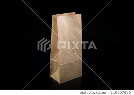 Recyclable craft paper bag for purchases, gifts and takeaway food mock up on black background. Environmentally friendly than single-use plastic bags 110907930