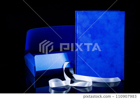 Best gift for men. Man gift concept. Blue notebook with blue gift box on black background. Copy space text. Valentine's day, wedding, birthday and special occasion gift concept. Copy space for text. 110907983