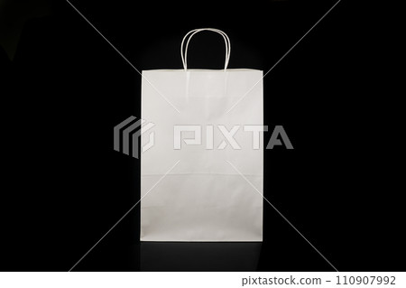 Recyclable craft paper bag for purchases, gifts and takeaway food mock up on black background. Environmentally friendly than single-use plastic bags 110907992
