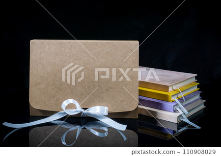 Best gift for men. Man gift concept. Various notebooks with craft gift box black background. Copy space text. Valentine's day, wedding, birthday and special occasion gift concept. Copy space for text. 110908029