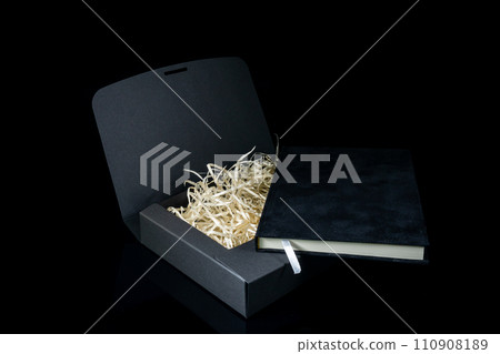 Best gift for men. Man gift concept. Black notebook with black gift box on black background. Copy space text. Valentine's day, wedding, birthday and special occasion gift concept. Copy space for text. 110908189