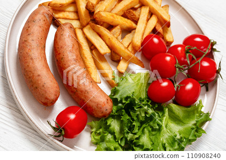 sausages with potato, lettuce, tomatoes, top view sausages with potato, lettuce, tomatoes, top view 110908240