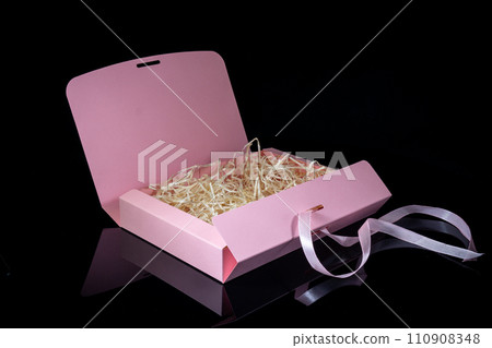 Blank package mockup. Pink paper box on black mirror background. Top view. 110908348