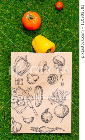 a paper bag lies on the green grass with fruits and vegetables around, moss, mock up 110908383