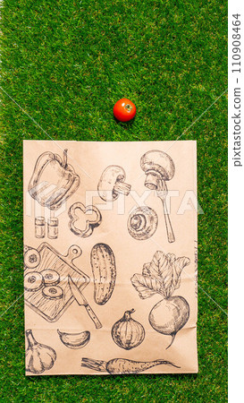 a paper bag lies on the green grass with fruits and vegetables around, moss, mock up 110908464