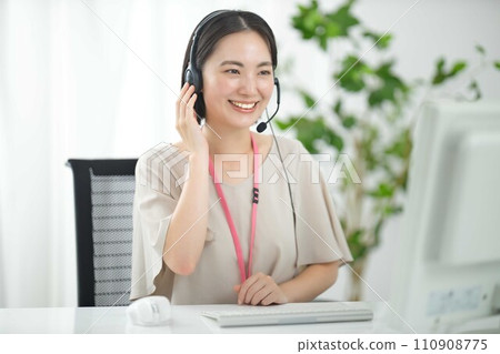 A young operator works while wearing headphones. 110908775