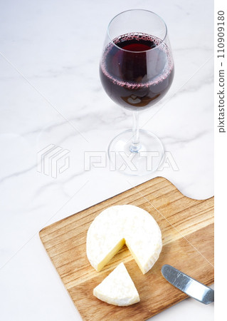 Red wine and camembert cheese poured into a wine glass Red wine and camembert cheese poured into a wine glass 110909180