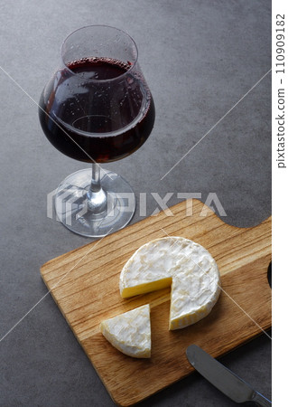 Red wine and camembert cheese poured into a wine glass Red wine and camembert cheese poured into a wine glass 110909182