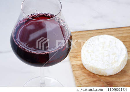 Red wine and camembert cheese poured into a wine glass 110909184