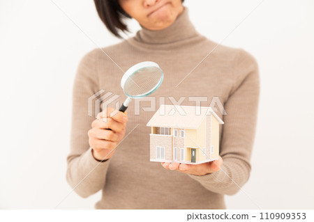 Middle-aged woman with a house model and a loupe Middle-aged woman with a house model and a loupe 110909353