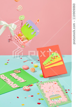 The background is divided into pastel pink and blue. Happy birthday cards with cute drawings. Colorful gummy candies and confetti are decorated on the background. The background is divided into pastel pink and blue. Happy birthday cards with cute drawings. Colorful gummy candies and confetti are decorated on the background. 110909860