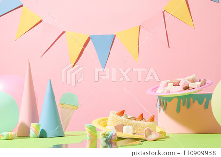A triangular flag string hangs on a pink background. Macaron, cakes displayed with ice cream origami, birthday cake origami. Birthday scene with pastel color tones. A triangular flag string hangs on a pink background. Macaron, cakes displayed with ice cream origami, birthday cake origami. Birthday scene with pastel color tones. 110909938