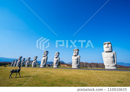 Blue sky, deer statue and moai 110910635
