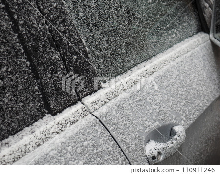 Driver's door of a car covered in snow 110911246