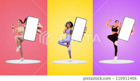 Smiling millennial european, black, arab women in sportswear show phone with empty screen Smiling millennial european, black, arab women in sportswear show phone with empty screen 110911406