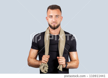 Positive confident strong young caucasian guy coach in black sportswear, with towel, look at camera 110911441