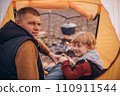 Man and boy tourists autumn time leisure, vacation hiking or traveling touristic activity. Family camping, father and little son relax in forest camp. 110911544