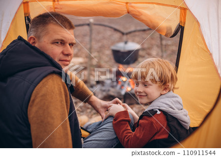 Man and boy tourists autumn time leisure, vacation hiking or traveling touristic activity. Family camping, father and little son relax in forest camp. 110911544
