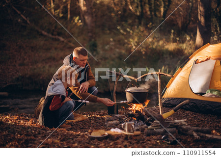 Man and boy tourists autumn time leisure, vacation hiking or traveling touristic activity. Family camping, father and little son relax in forest camp. Man and boy tourists autumn time leisure, vacation hiking or traveling touristic activity. Family camping, father and little son relax in forest camp. 110911554