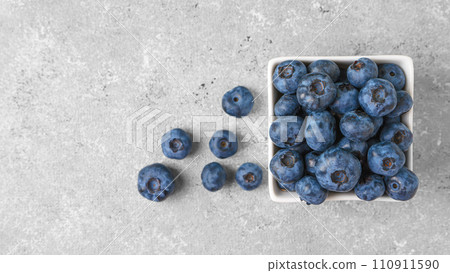 Fresh blueberries in a small square bowl on gray concrete background with copy space 110911590