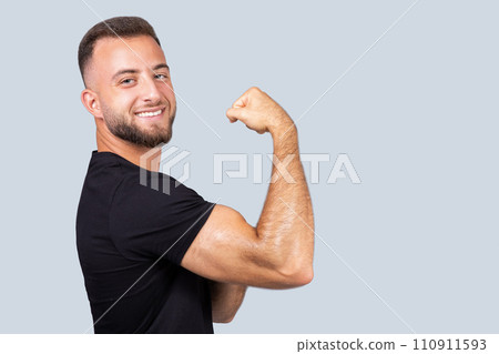 Happy confident strong millennial caucasian man coach in sportswear show muscle biceps on hand 110911593