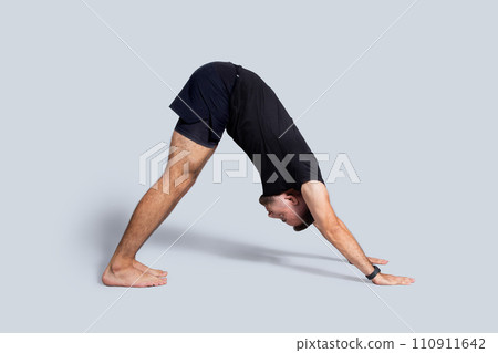 Strong young european guy in sportswear practice yoga, breath exercises, enjoy workout alone Strong young european guy in sportswear practice yoga, breath exercises, enjoy workout alone 110911642