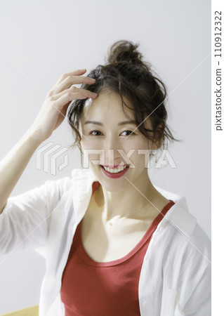 Portrait of a young woman with bun hair, vertical position 110912322