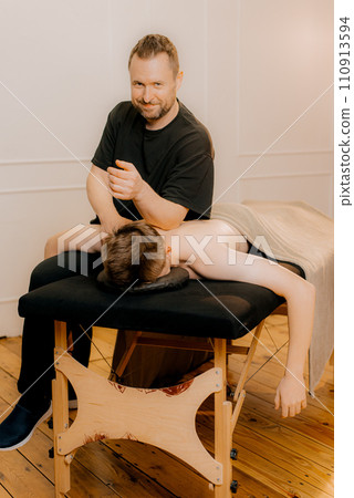 Physiotherapist massaging male patient with injured neck muscle. Sports injury treatment, reabilitation. Neurological physical examination. Osteopathy, chiropractic, physiotherapy 110913594