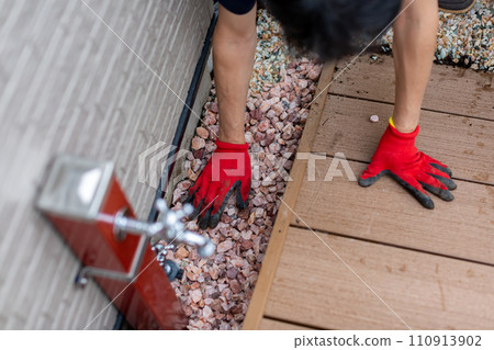 A man laying gravel in the garden, gardening A man laying gravel in the garden, gardening 110913902