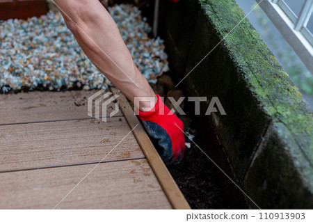 A man laying gravel in the garden, gardening A man laying gravel in the garden, gardening 110913903