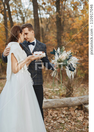 Professional wedding photographer taking pictures of the bride and groom in nature in autumn Professional wedding photographer taking pictures of the bride and groom in nature in autumn 110917046