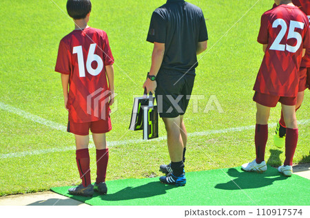 Youth soccer match (players preparing for substitution and fourth referee) 110917574