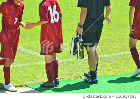 Youth soccer match (players preparing for substitution and fourth referee) 110917583