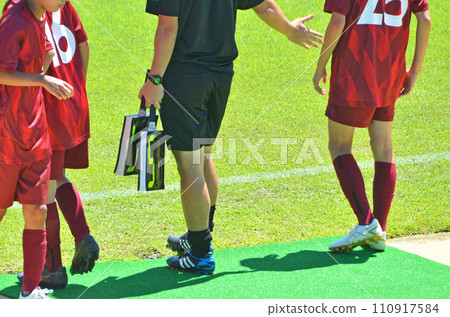 Youth soccer match (players preparing for substitution and fourth referee) 110917584