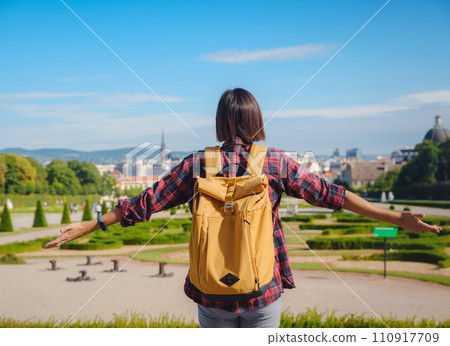 Female tourist traveling in Austria, capital city Vienna. summer female solo trip to Europe, happy young woman walking in park near Belvedere palace complex in Baroque style. 110917709