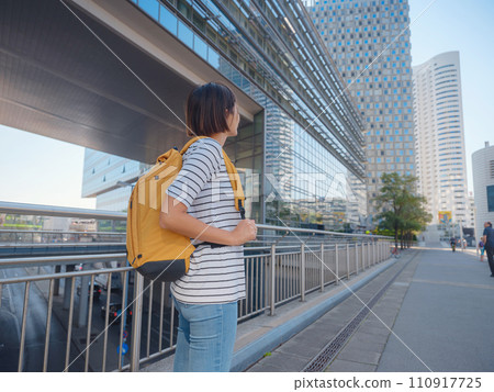Female tourist traveling in Austria, capital city Vienna. summer female solo trip to Europe, happy young woman walking in Donaustadt district street 110917725