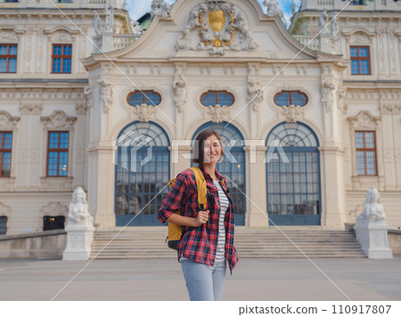 Female tourist traveling in Austria, capital city Vienna. summer female solo trip to Europe, happy young woman walking in park near Belvedere palace complex in Baroque style. Female tourist traveling in Austria, capital city Vienna. summer female solo trip to Europe, happy young woman walking in park near Belvedere palace complex in Baroque style. 110917807