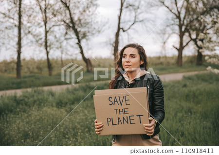 Beautiful young woman holding a banner with the text Save the planet. 110918411