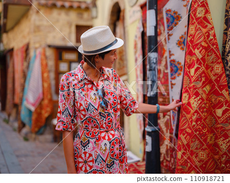female summer travel to Antalya, Turkey. young asian woman in red dress walk old town Kalechi , female tourist traveler discover interesting places and popular tourist attraction, look on capret 110918721