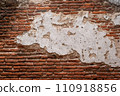 Old brick wall with large piece of stucco in the middle 110918856