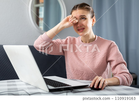 Young woman experiencing eye pain after working on laptop 110919163