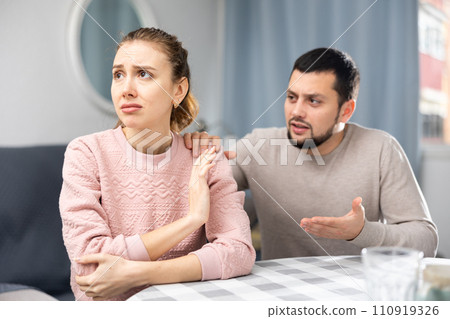 Man comforting his upset wife at home 110919326