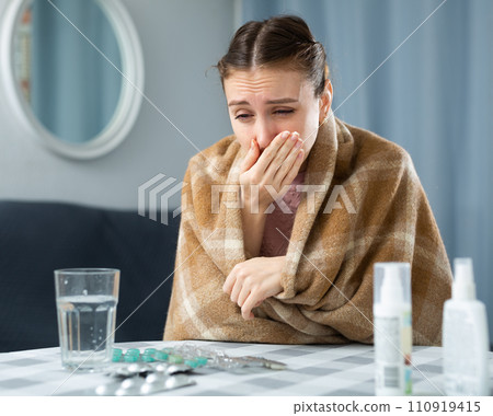 Woman with fever symptoms sitting at home Woman with fever symptoms sitting at home 110919415