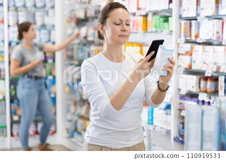 In pharmacy visitor scan QR Code and reads composition of cream for problematic skin. In pharmacy visitor scan QR Code and reads composition of cream for problematic skin. 110919533