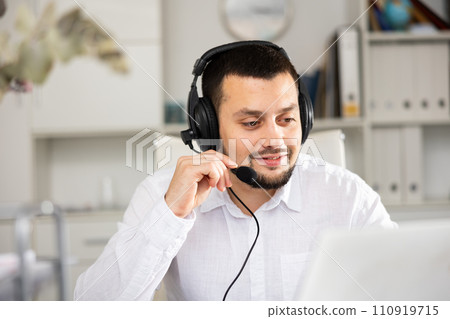 Portrait of positive man office worker wearing headset Portrait of positive man office worker wearing headset 110919715