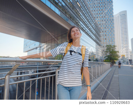Female tourist traveling in Austria, capital city Vienna. summer female solo trip to Europe, happy young woman walking in Donaustadt district street Female tourist traveling in Austria, capital city Vienna. summer female solo trip to Europe, happy young woman walking in Donaustadt district street 110920683